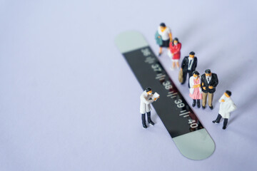 doctor miniature figure Check temperature paper with  patient on white background.