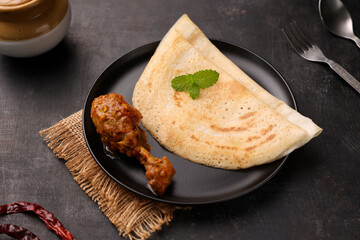 Dosa , Dosai, ghee roast with chicken curry popular South Indian Breakfast food, Kerala, Tamil Nadu India Sri Lanka. Masala dosa with non vegetarian Indian kadai chicken leg curry.