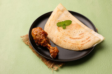 Dosa , Dosai, ghee roast with chicken curry popular South Indian Breakfast food, Kerala, Tamil Nadu India Sri Lanka. Masala dosa with non vegetarian Indian kadai chicken leg curry.