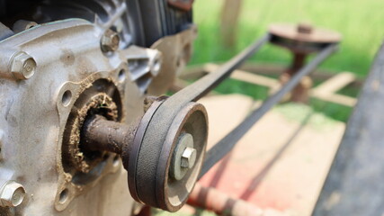 Close up the belt on the pulley. The metal core of the small engine transmits force through the...