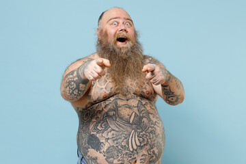 Young fat pudge obese chubby overweight blue-eyed bearded man has big belly with naked tattooed...