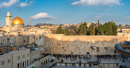 Fototapeta premium Panoramic view in the old city of Jerusalem at sunset, including the Western Wall and golden Dome of the Rock. 