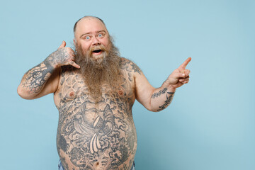 Young fun fat pudge obese chubby overweight blue-eyed bearded man has big belly with naked tattooed...