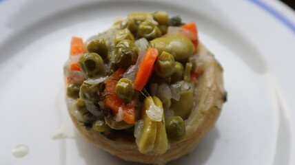 Healthy food Artichoke on the white plate. Close-up Artichoke food with beans, peas, onions and carrots. Delicious healthy vegan food with olive oil.