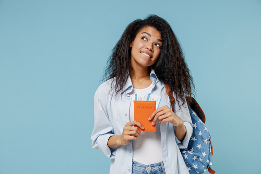 Traveler dreamful african tourist teen girl student in denim clothes point finger on passport ticket isolated on blue background Passenger travel abroad on weekends getaway Air flight journey concept