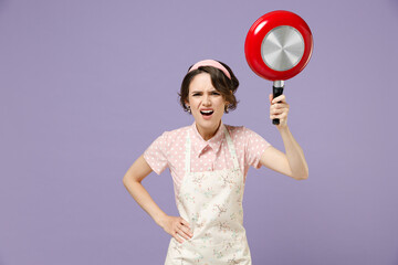 Young indignant angry abuse housewife housekeeper chef cook baker woman in pink apron threatening...