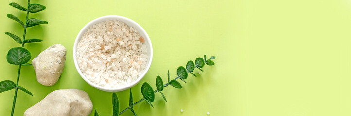 Natural cosmetics banner. Sea salt, essential oil, stones, plants, spices on a green background, top view, copy space, flat lay. Wellness skin care concept, organic cosmetics background