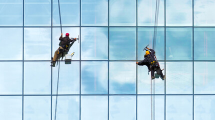 Group of workers cleaning windows service on high rise building. Workers cleaning glass curtain wall. Special job concept, panoramic view - 436472322