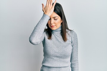 Young hispanic woman wearing casual clothes surprised with hand on head for mistake, remember...