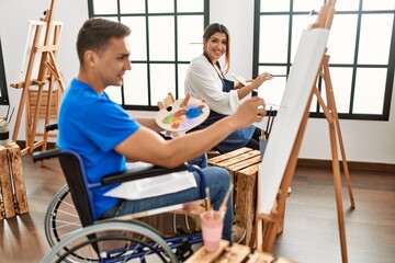 Obraz premium Two students smiling happy painting at art school.