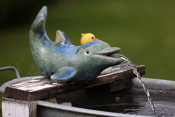 Decorative fountain in the garden in the form of a dolphin