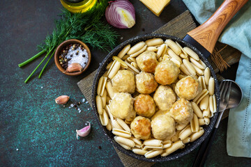 Italian pasta. Spaghetti with meatballs in cheese sauce on a dark  stone or concrete background. Top view, flat lay background. Copy space.