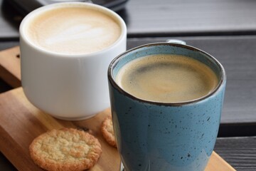 Two cups of coffee and a cookie as a close up