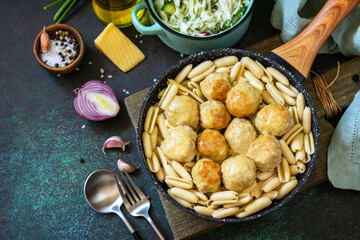 Italian pasta. Spaghetti with meatballs in cheese sauce on a dark  stone or concrete background. Copy space.