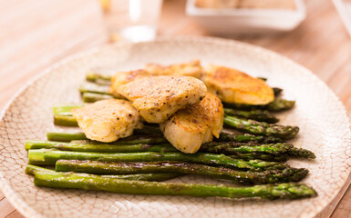 cooked dish. Chicken nuggets with green asparagus on plate