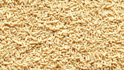 Background, texture from dry granular yeast, top view, macro. Active dry yeast, top view. Heap of...