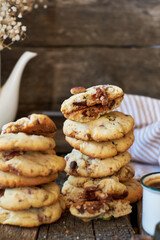 Cookies with caramel, pistachios and chocolate. Wooden background, side view