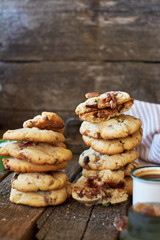 Cookies with caramel, pistachios and chocolate. Wooden background, side view