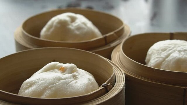 hot red pork steamed stuff bun or white bread with point and heat vapor or smoke in wooden basket for morning food or breakfast and dim sum snack at restaurant on slow motion