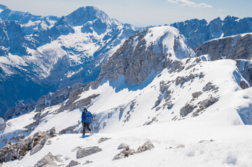 Fototapeta na wymiar climber on the top of the alpine mountain Mala Mojstrovka against the backdrop of snowy alps 