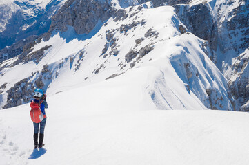Fototapeta na wymiar slender positive smiling girl climber mountaineer on a snowy alpine slope