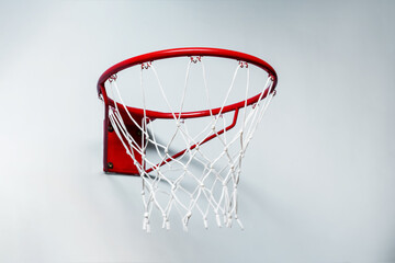 Close up view of red metal basketball hoop with sports net on white wall