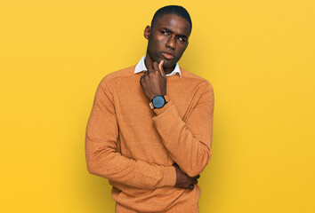 Young african american man wearing casual clothes serious face thinking about question with hand on chin, thoughtful about confusing idea