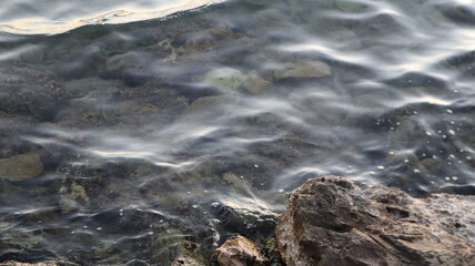 Fototapeta premium Orange gold sunset on sea surface. Sun reflection on water. Landscape under colorful sky at sunset. Orange sundown reflecting from calm Aegean sea at golden hours.