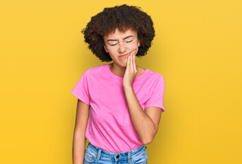 Young hispanic girl wearing casual clothes touching mouth with hand with painful expression because of toothache or dental illness on teeth. dentist