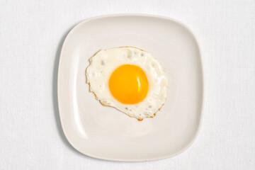 fried eggs on a square white plate