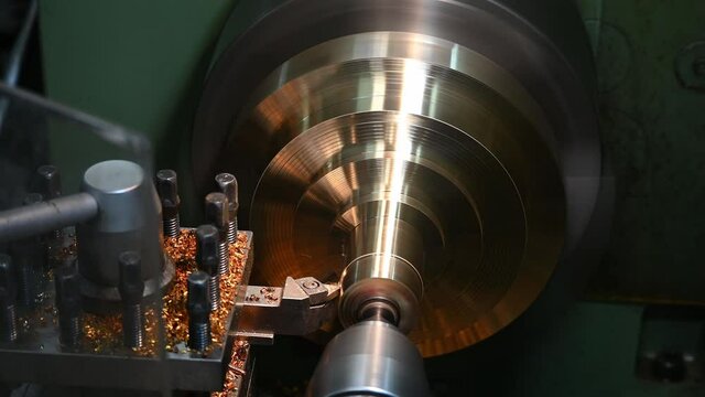 The operation of lathe machine cutting the brass shaft material. The metalworking process by turning machine.