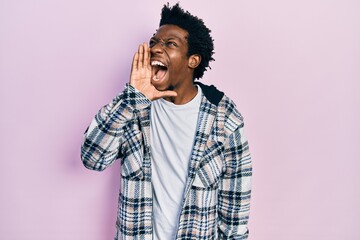 Young african american man wearing casual clothes shouting and screaming loud to side with hand on mouth. communication concept.