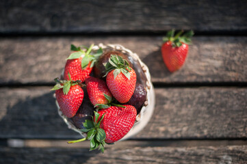 basket of fresh spring juicy strawberries in the sunset sun on a park bench natural picnic