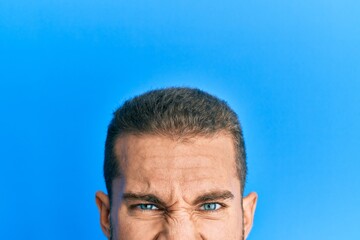 Young caucasian man showing head and half face sticking tongue out happy with funny expression.