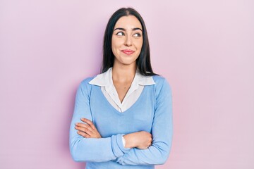 Fototapeta premium Beautiful woman with blue eyes standing over pink background smiling looking to the side and staring away thinking.