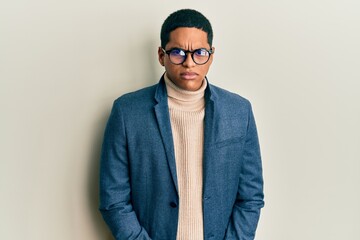 Young handsome hispanic man wearing elegant clothes and glasses skeptic and nervous, frowning upset...
