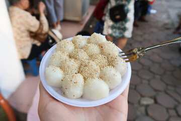 Vietnamese glutinous rice balls (Banh troi) on a bowl on street, with sesame seeds. Also known as...