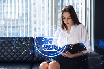 Portrait of attractive businesswoman working with documents and thinking how to protect clients confidential information and cyber security. IT hologram padlock icons over office background.