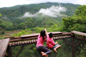 Naklejka premium mother and son enjoyed fog view from top of mountains