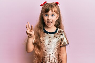 Little caucasian girl kid wearing festive sequins dress showing and pointing up with fingers number three while smiling confident and happy.