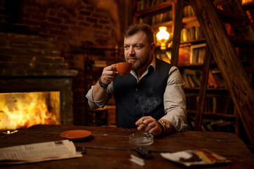 Man with cup of tea smokes a cigarette,