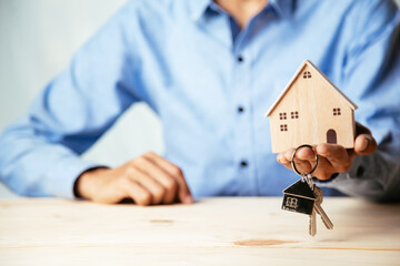 House model with real estate agent and customer discussing for contract to buy house, insurance or...