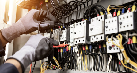 Electrician engineer tests electrical installations and wires on relay protection system....