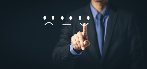 Customer Service and Satisfaction Concept Businessmen touch the virtual screen on happy smiley icons to achieve service satisfaction and feedback with excellent rated reviews.