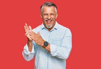 Middle age grey-haired man wearing casual clothes clapping and applauding happy and joyful, smiling proud hands together