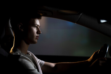 Joven conduciendo un automóvil de noche