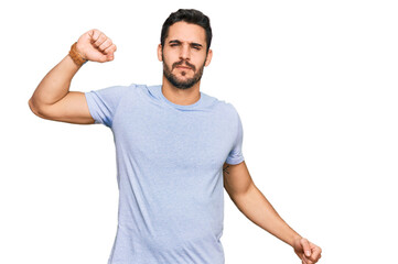 Young hispanic man wearing casual clothes stretching back, tired and relaxed, sleepy and yawning for early morning