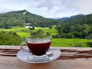 cup of tea on the terrace with rice field and mountains view background
