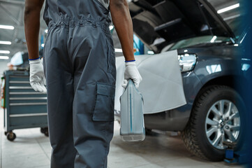 Fototapeta na wymiar Male mechanic holds oil canister, car service