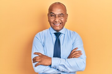 Middle age latin man wearing business clothes with arms crossed gesture winking looking at the...